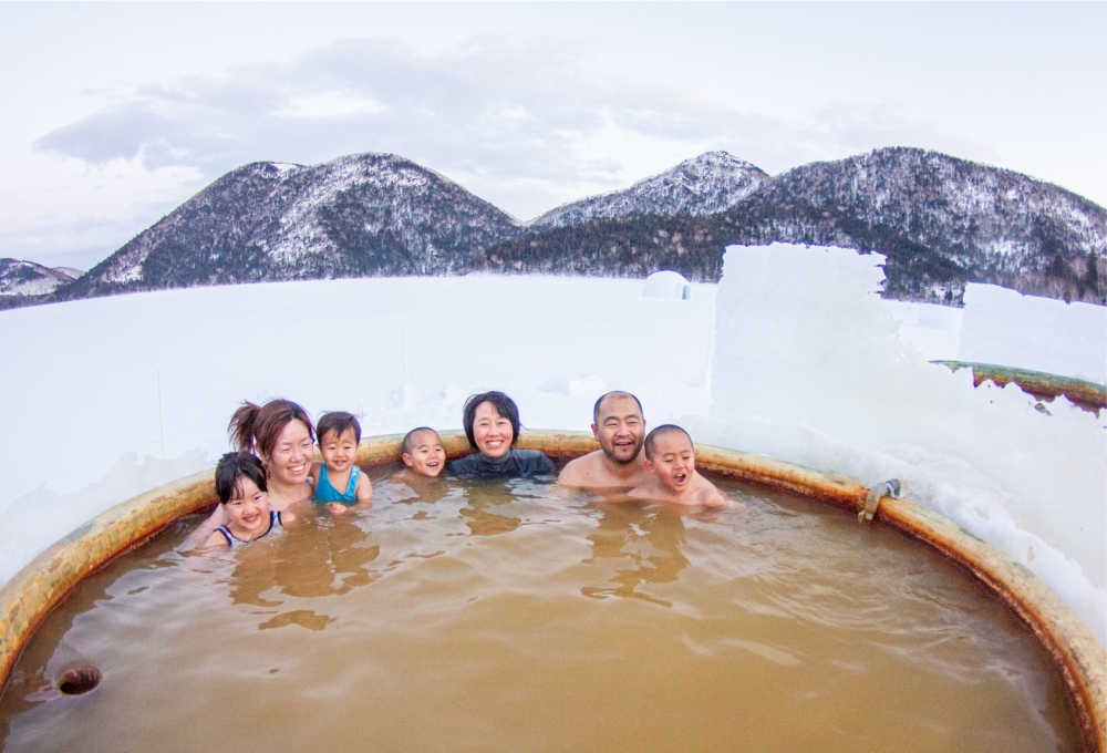 氷上露天風呂で歓談するグループ